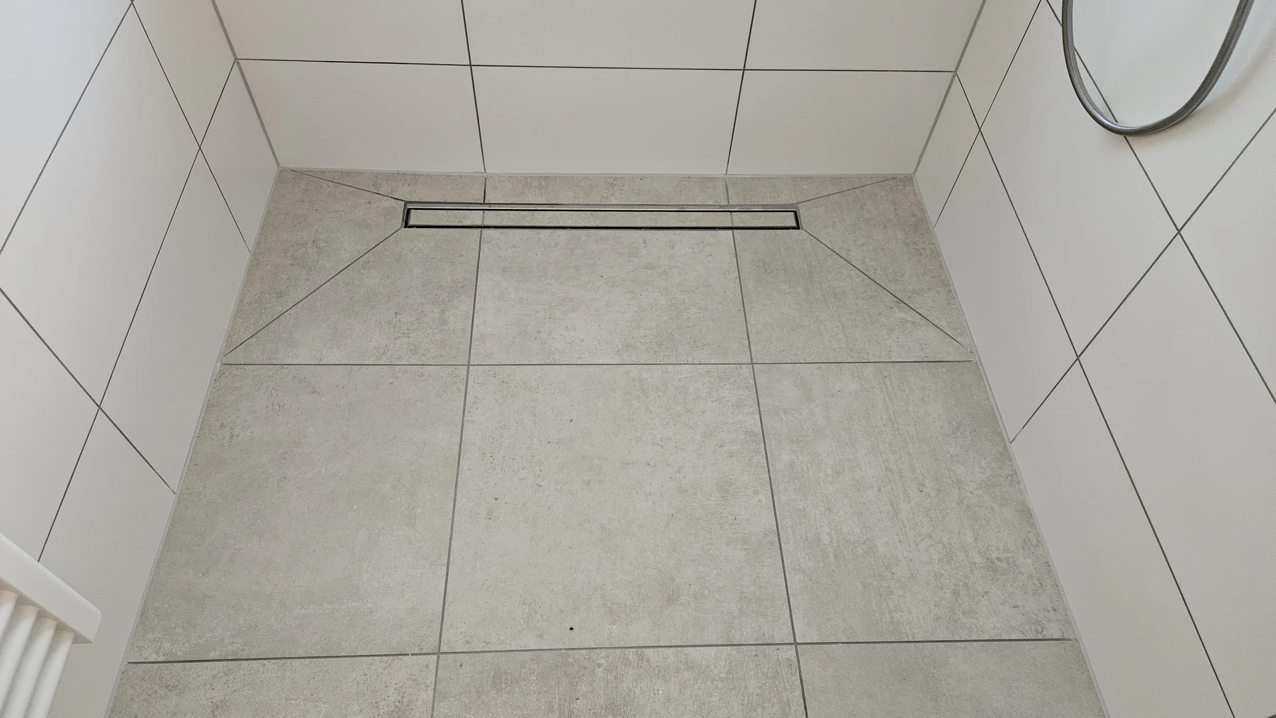 Geflieste bodengleiche Dusche mit wandnaher Rinne und Gefälleflächen