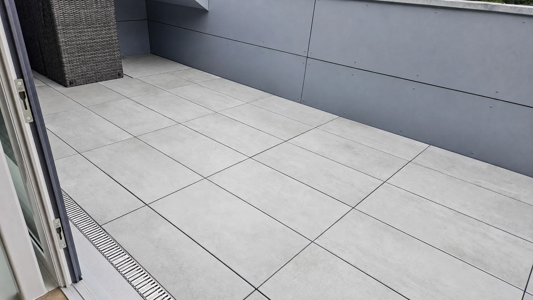 Dachterrasse mit 40 mal 80 Zentimeter großen Platten auf Stelzlagern und Entwässerungsrinne in Hannover
